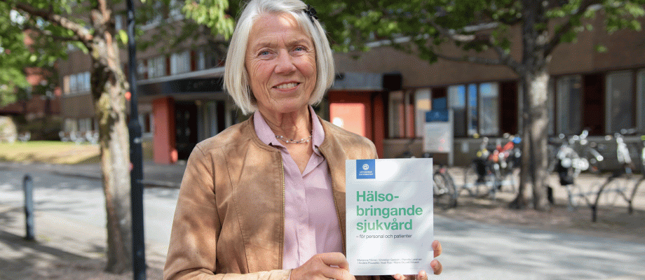 foto av forskaren Marianne Törner som visar sin bok Hälsobringande sjukvård - för personal och patienter